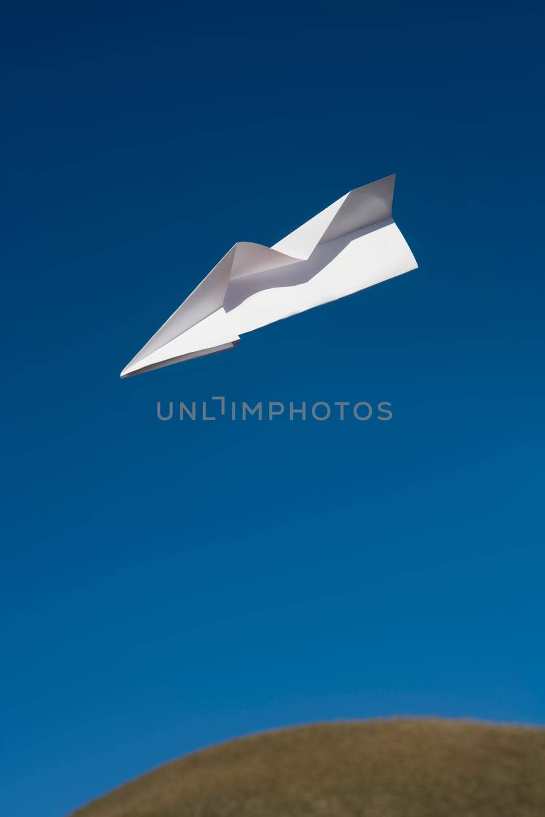 Paper Airplane flying towards blue sky