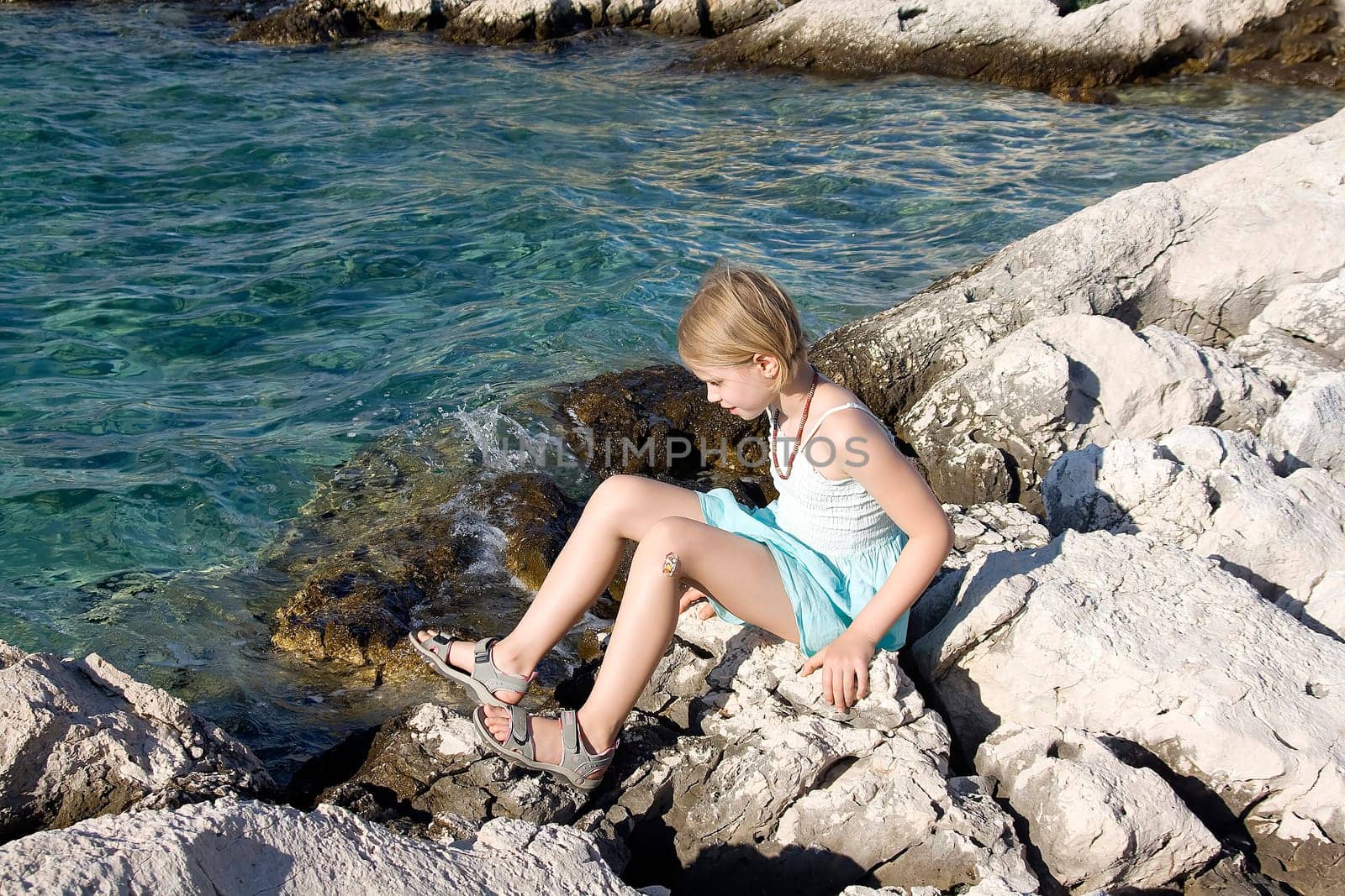 little girl sitting on the rocks