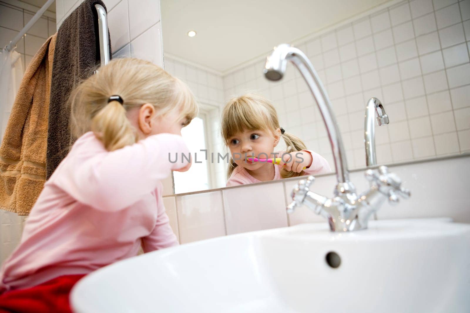 Baby Girl with toothbrush in the bathroom