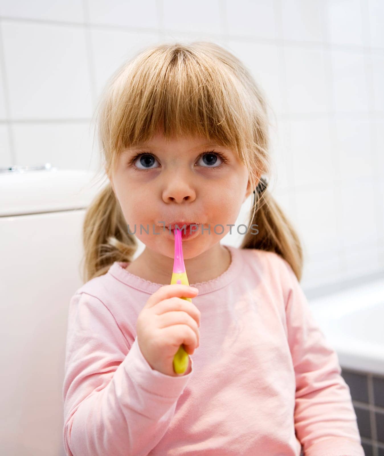 Baby Girl with toothbrush in the bathroom