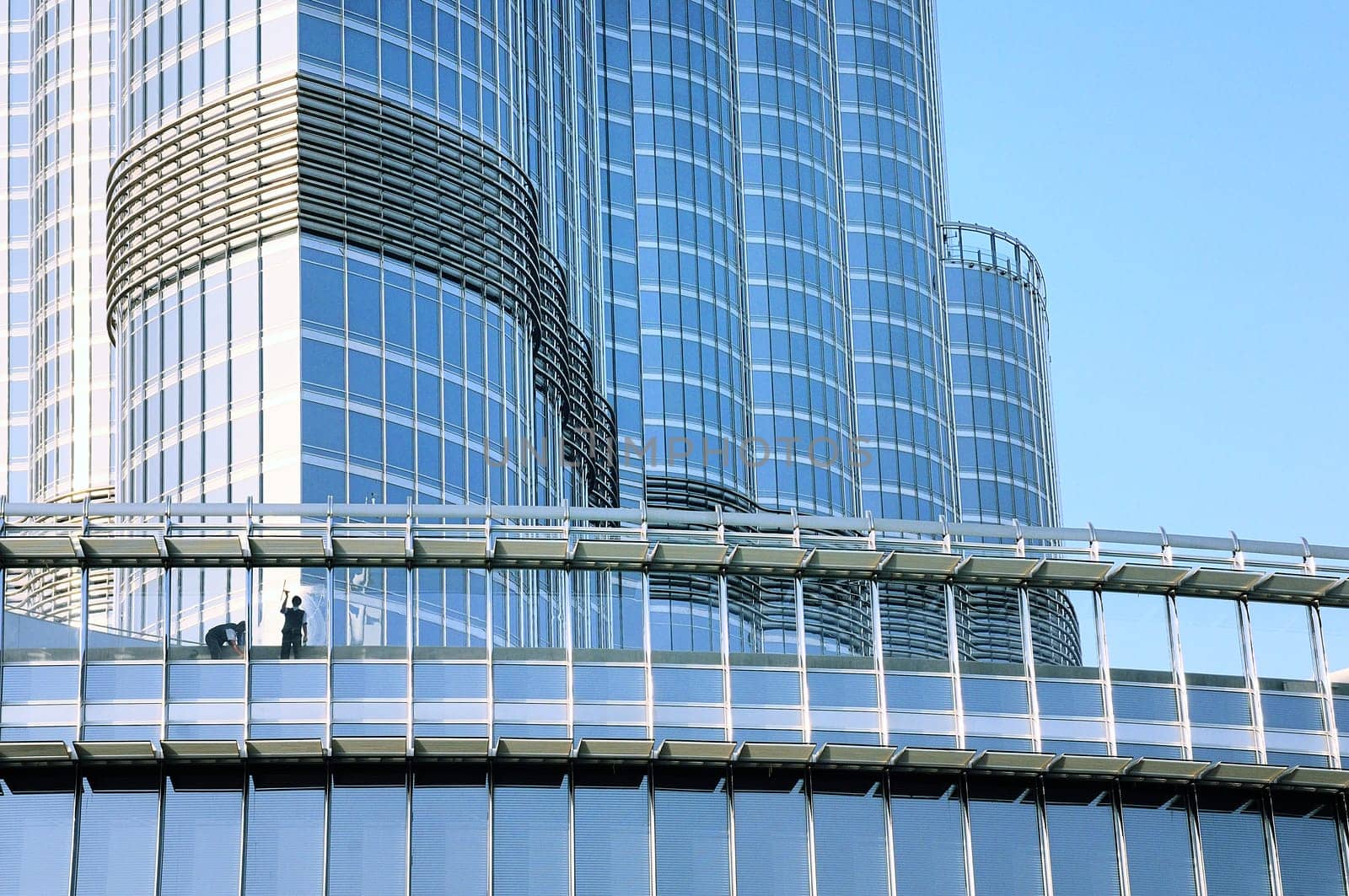 Two workers washing windows of the modern building.