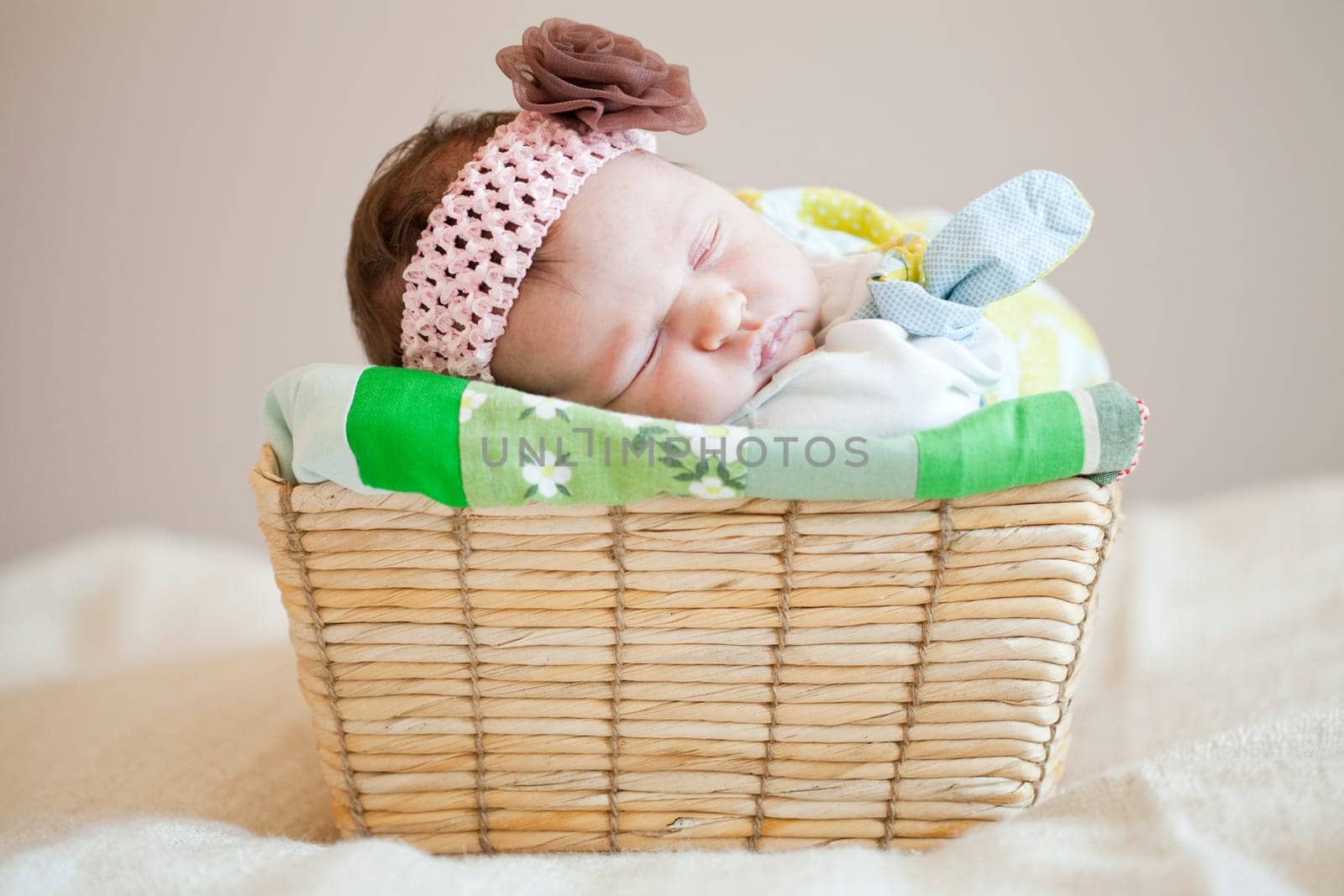 Portrait of a cute newborn baby girl sleeping in a basket