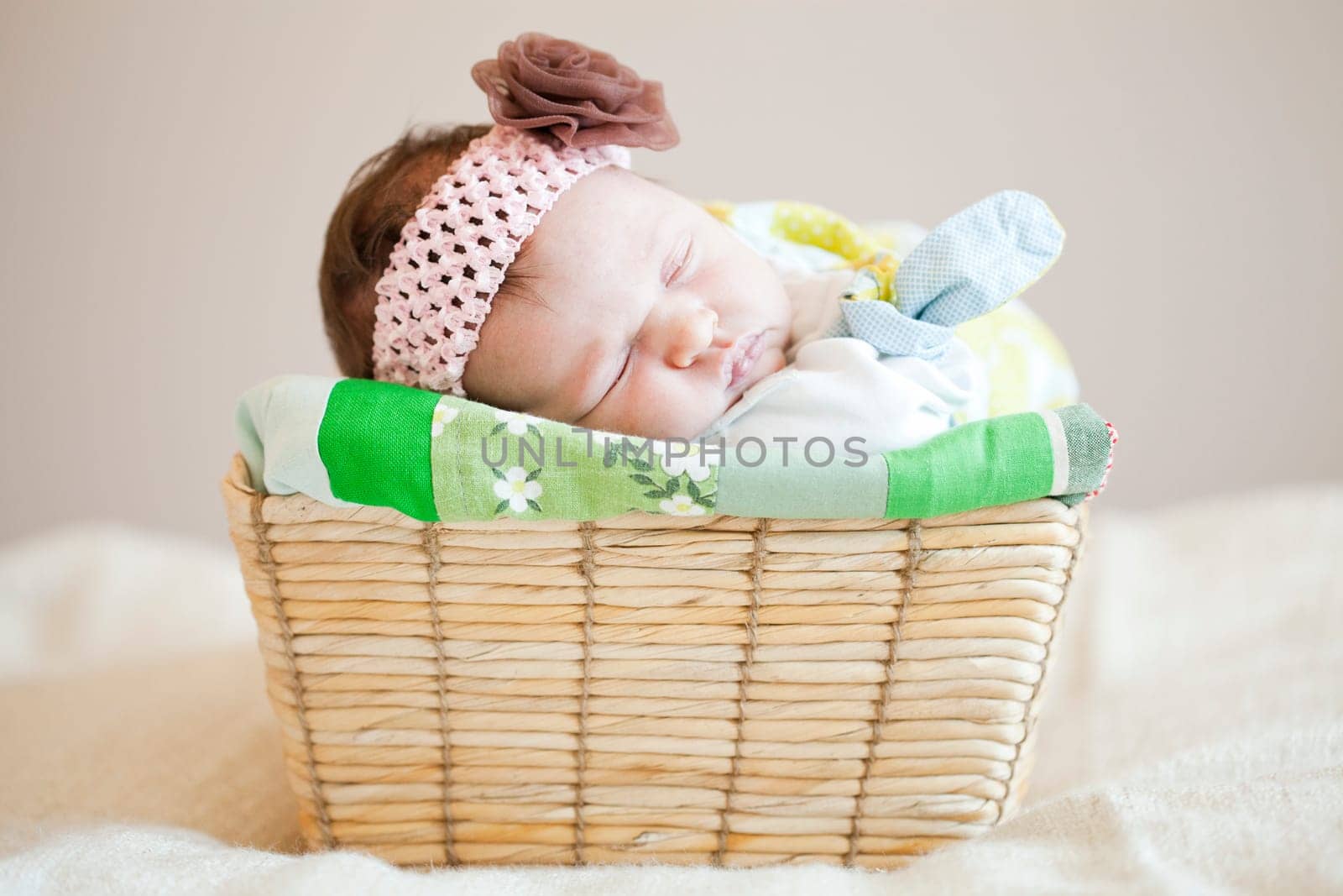 Portrait of a cute newborn baby girl sleeping in a basket