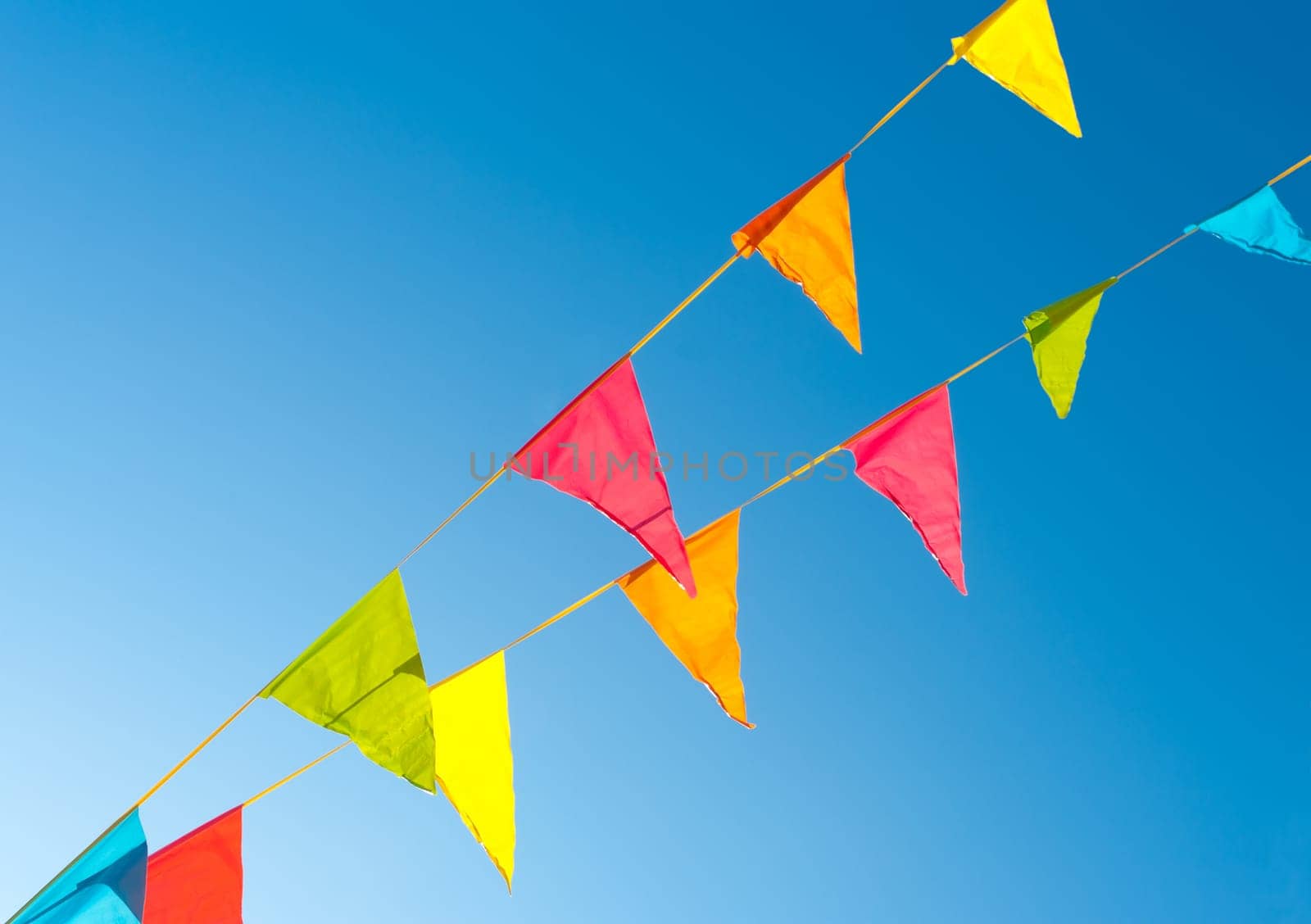 colorful bunting flags against a blue saturated sky