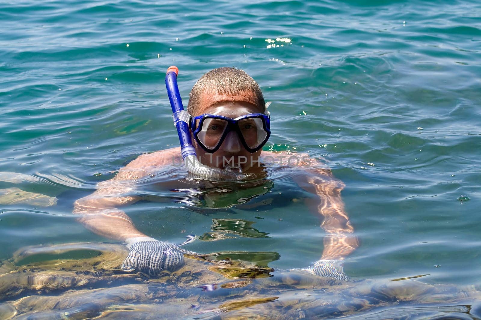 man in the water with fins mask and snorkel