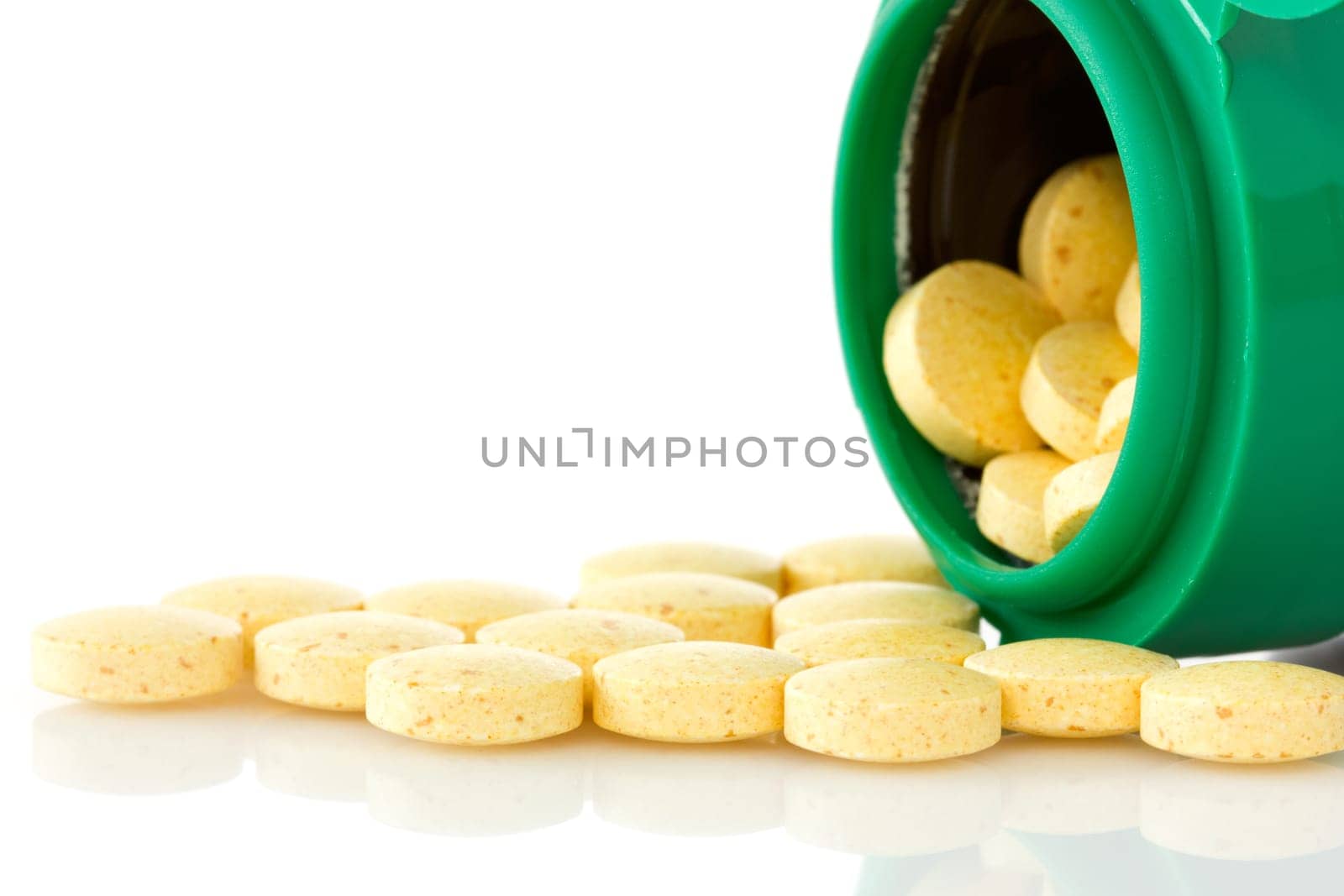 pill bottle with yellow pills on white background