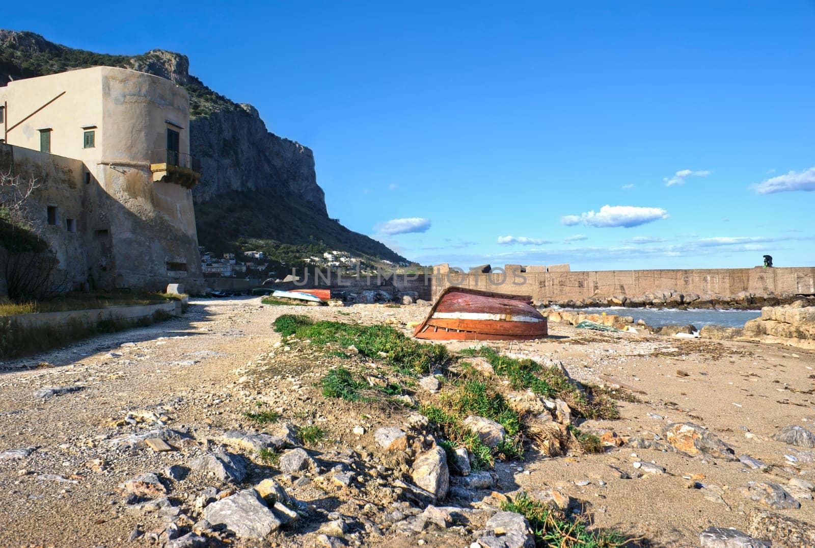 landscape of Palermo, Arenella- Sicily. old boats and fisherman in the distance