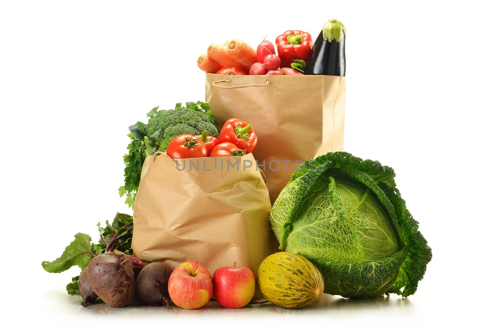 Composition with raw vegetables and shopping bag isolated on white