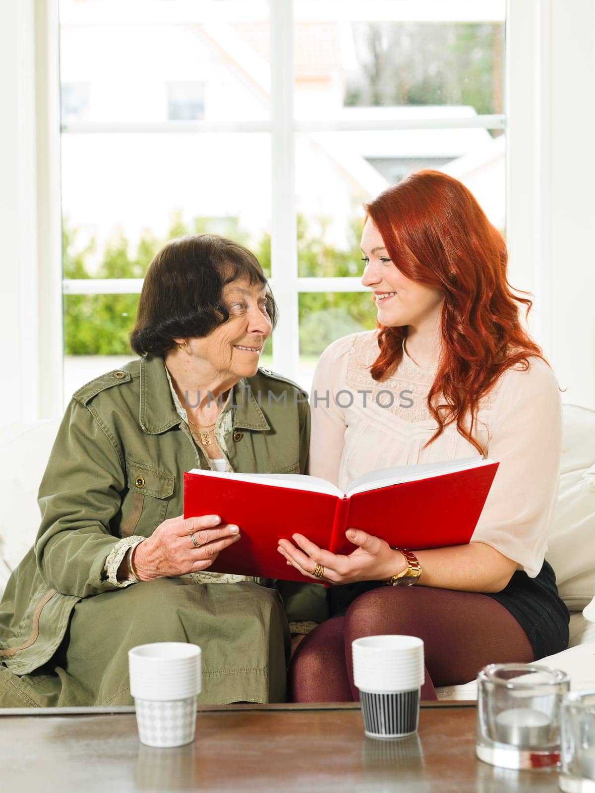 Young woman and her Grandmother looking in the Photo Album