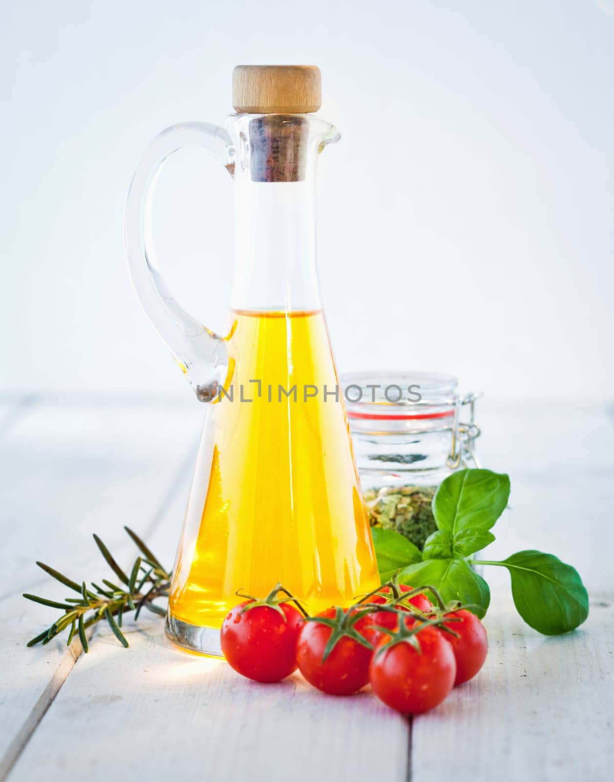 Ingredients for Tagliatelle, olive oil, tomatoes, fresh basil and herbs for seasoning, standing on painted white boards.