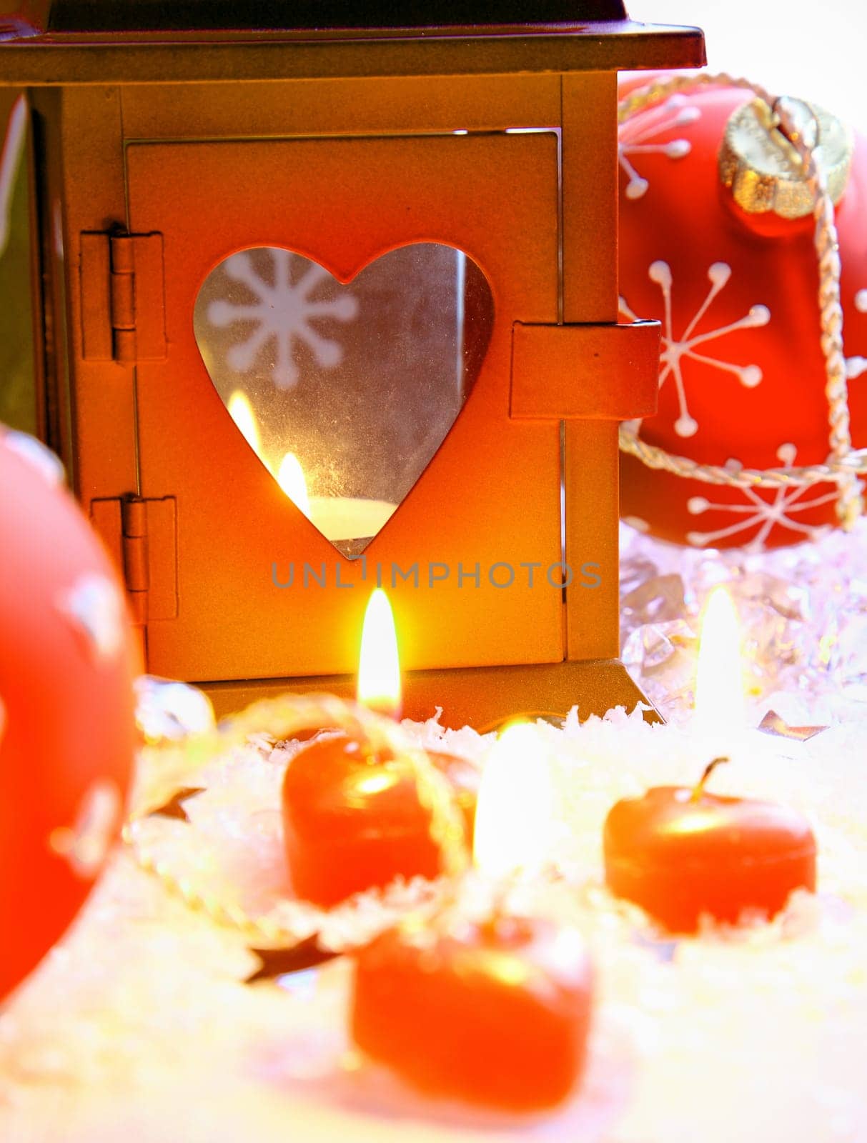 Christmas Lantern with heart shaped xmas candles on a conceptual winter background