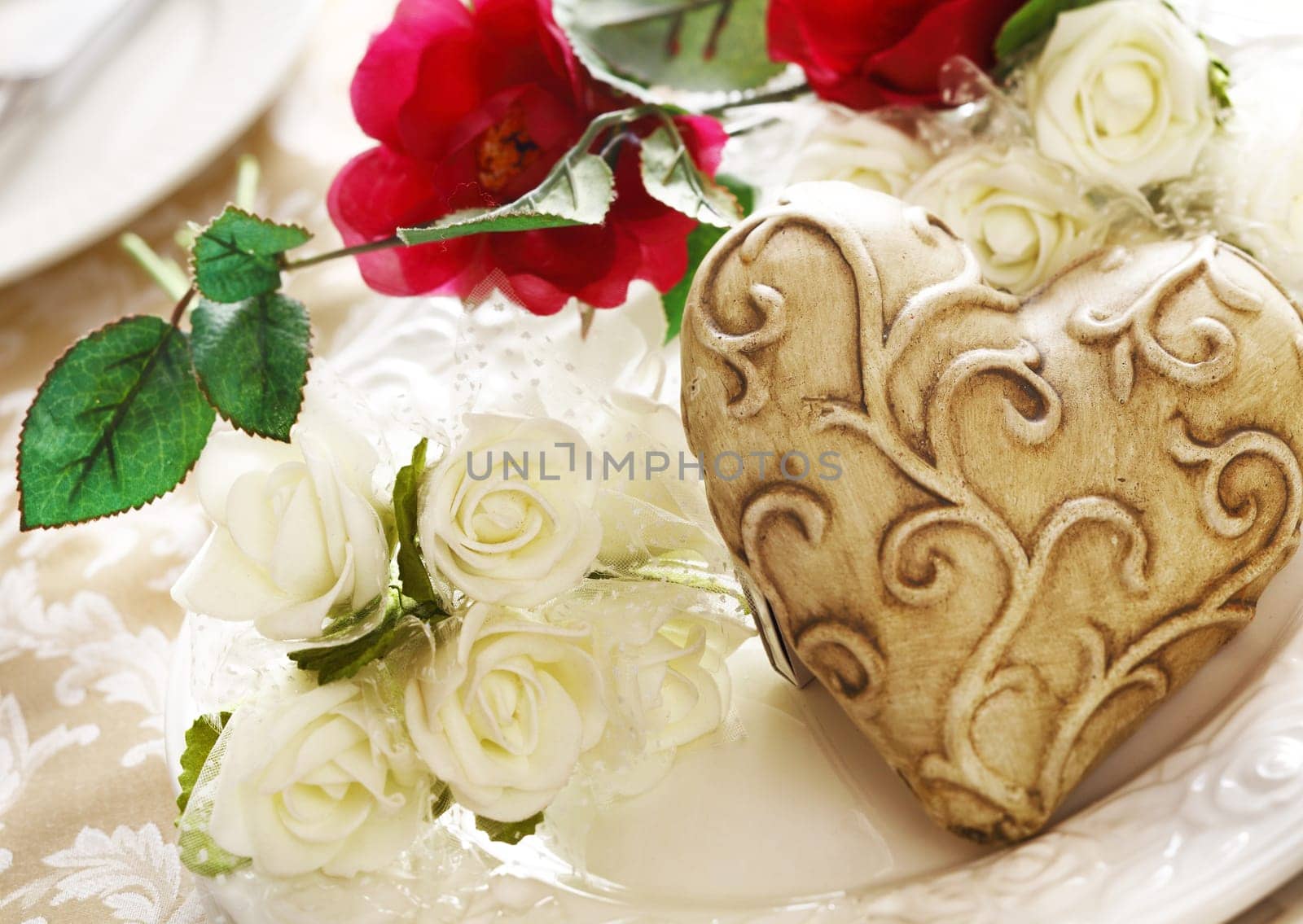 Decorative Valentine heart on a place setting with a bouquet of white roses