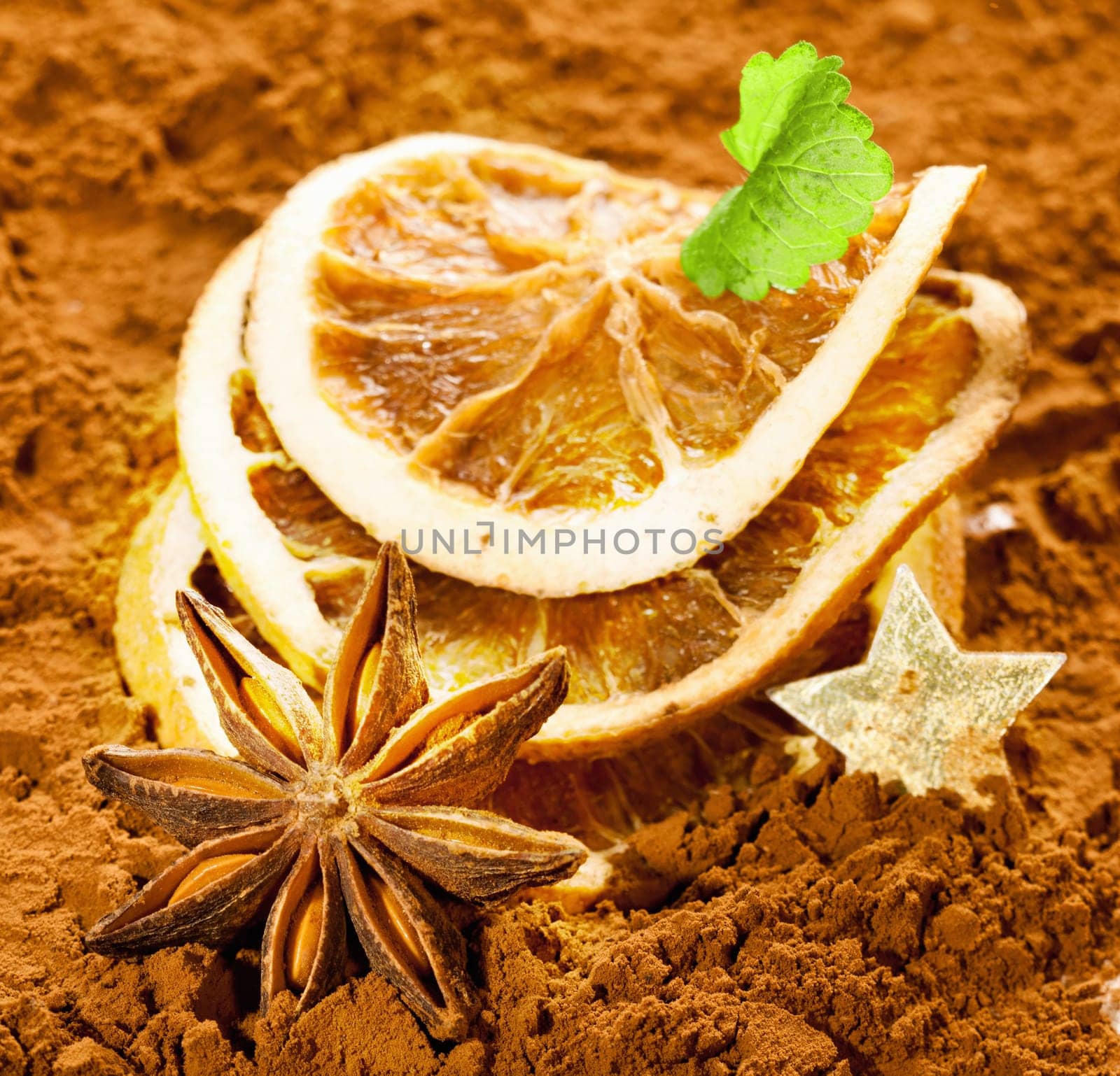 Dried orange slices with anise and a golden star on a brown background