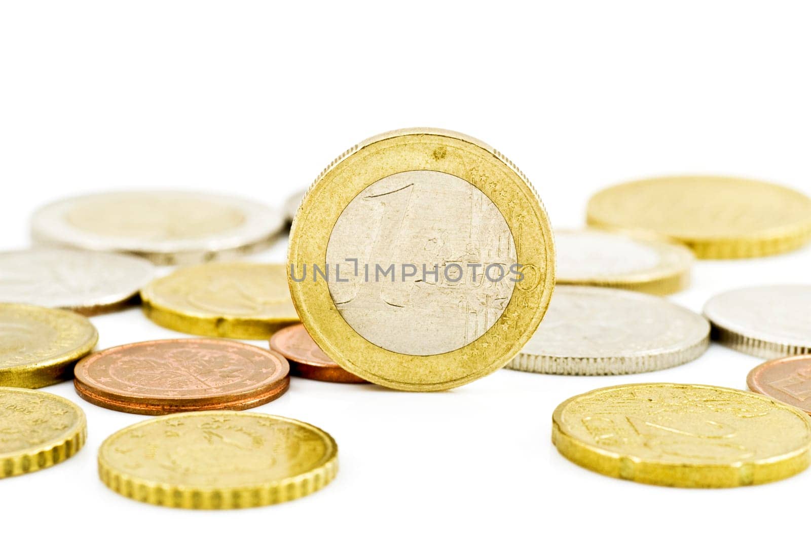 one euro coin in a middle of other coins