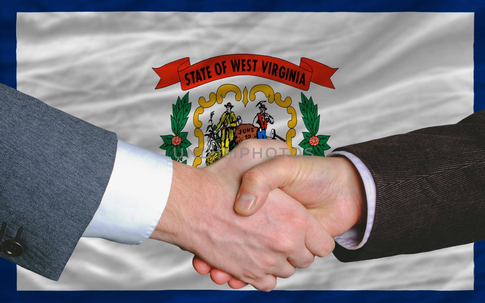 two businessmen shaking hands after good business investment agreement in front US state flag of west virginia