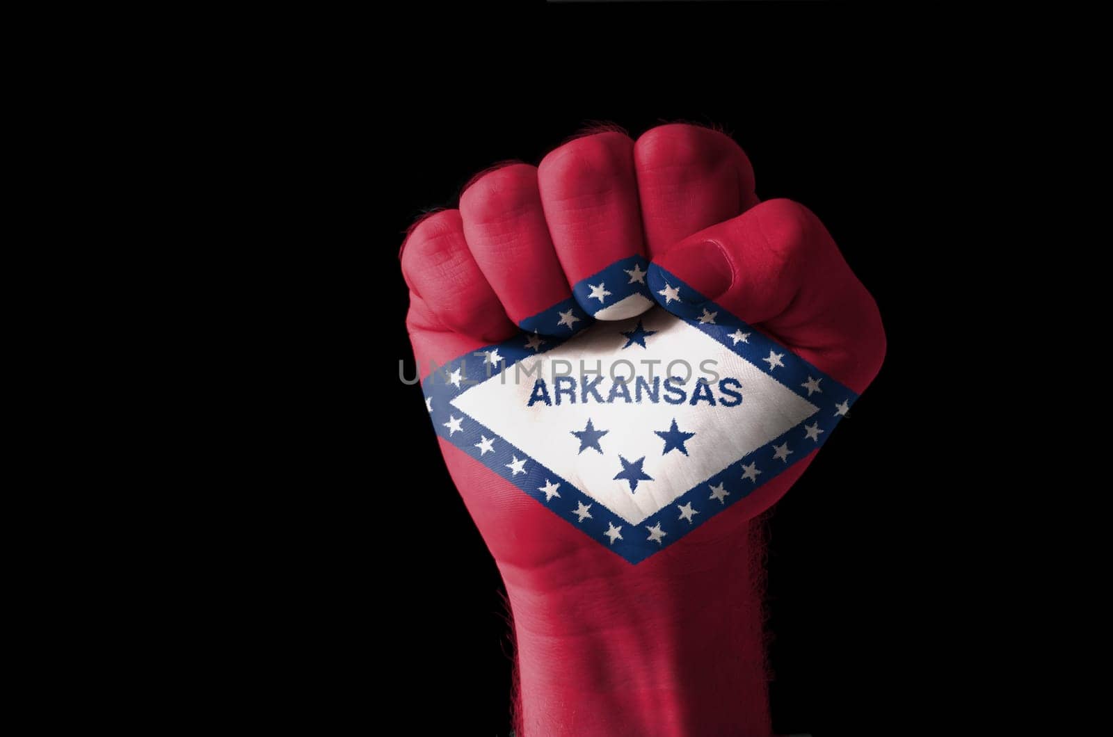 Low key picture of a fist painted in colors of american state flag of wyoming