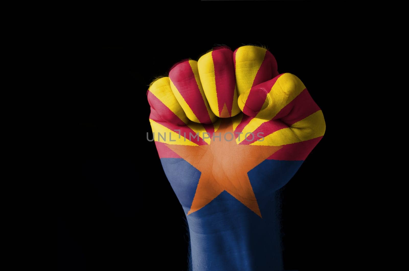 Low key picture of a fist painted in colors of american state flag of wyoming