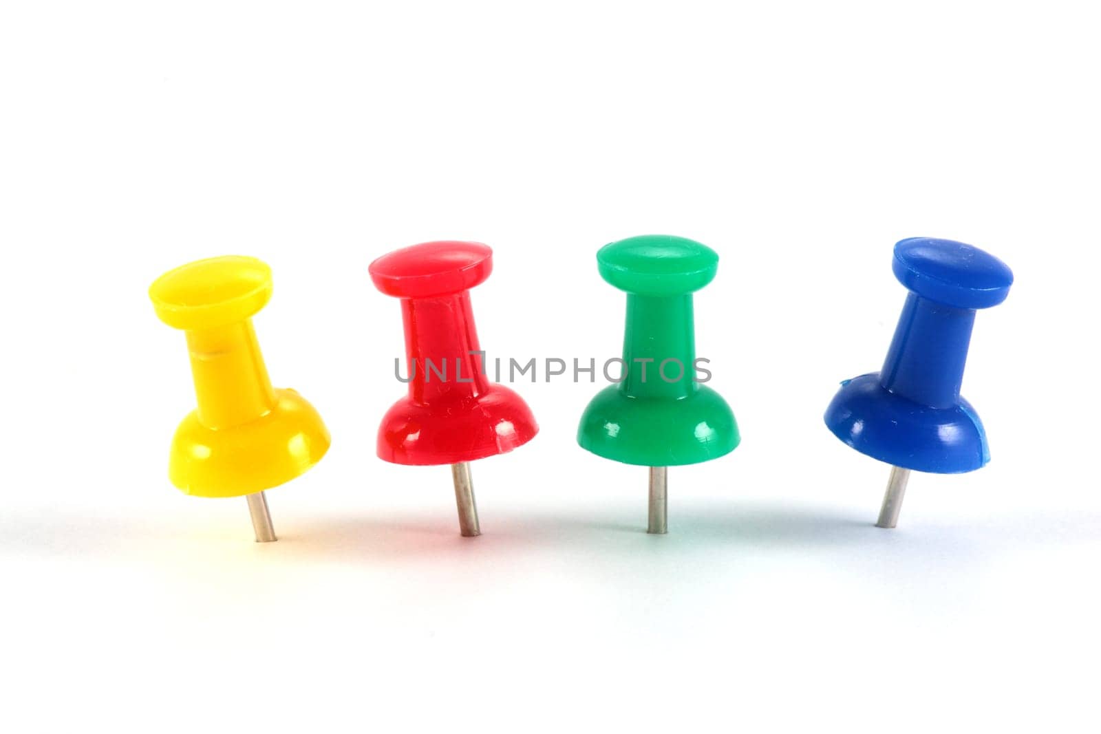 plastic pins of yellow red green and blue isolated on white background and horizontal