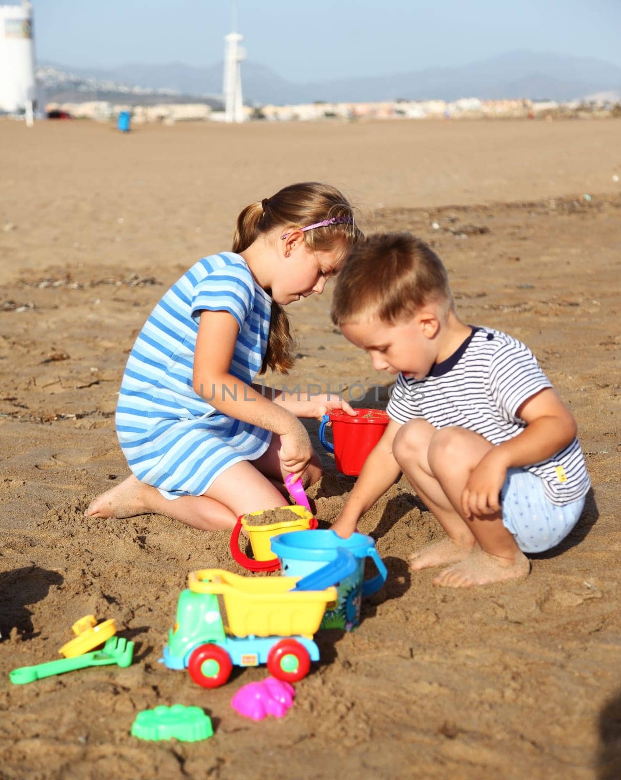 Kids playing with plastic toys on the beach