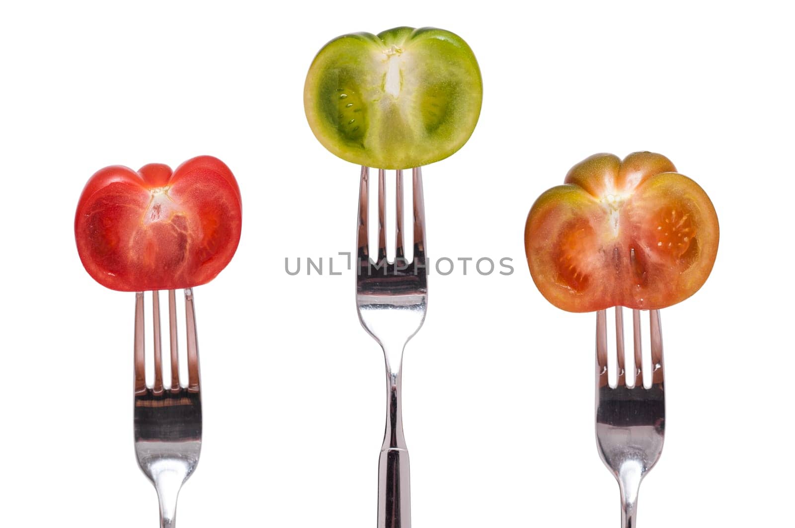 Three tomatoes on three forks against white background