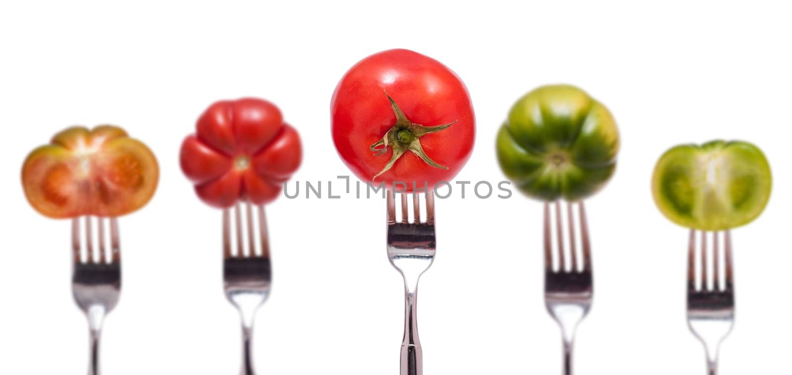 Five red and green tomatoes with fork