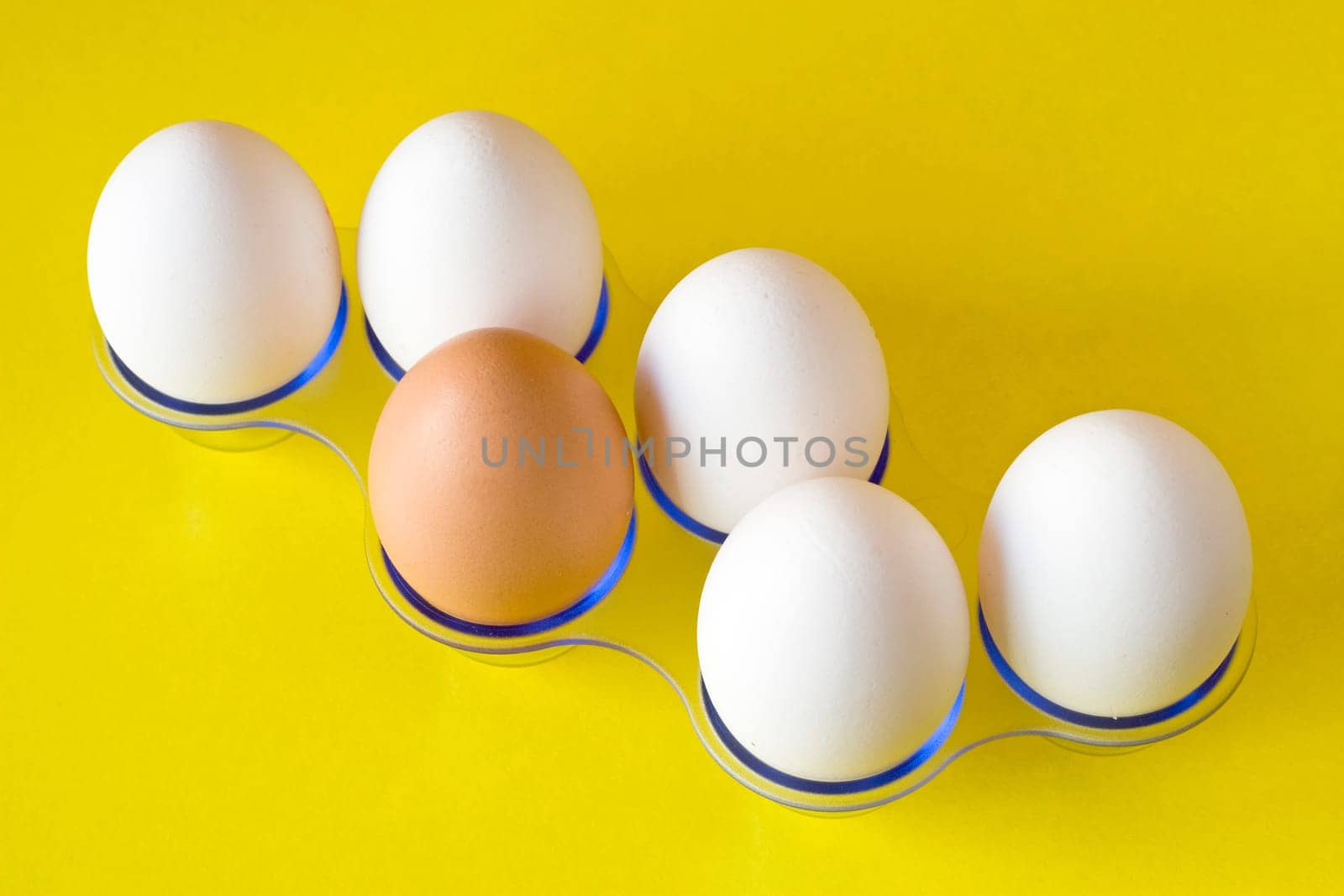 brown egg in a middle of white,on yellow background