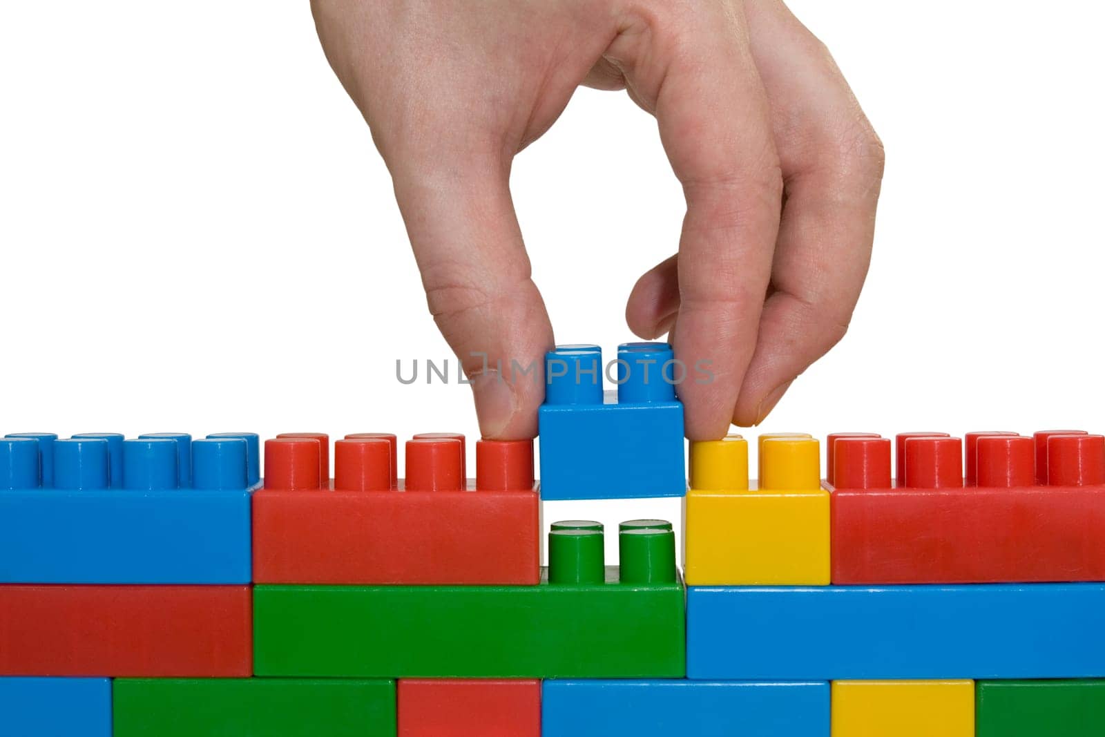 creativity concept. hand building up lego wall.