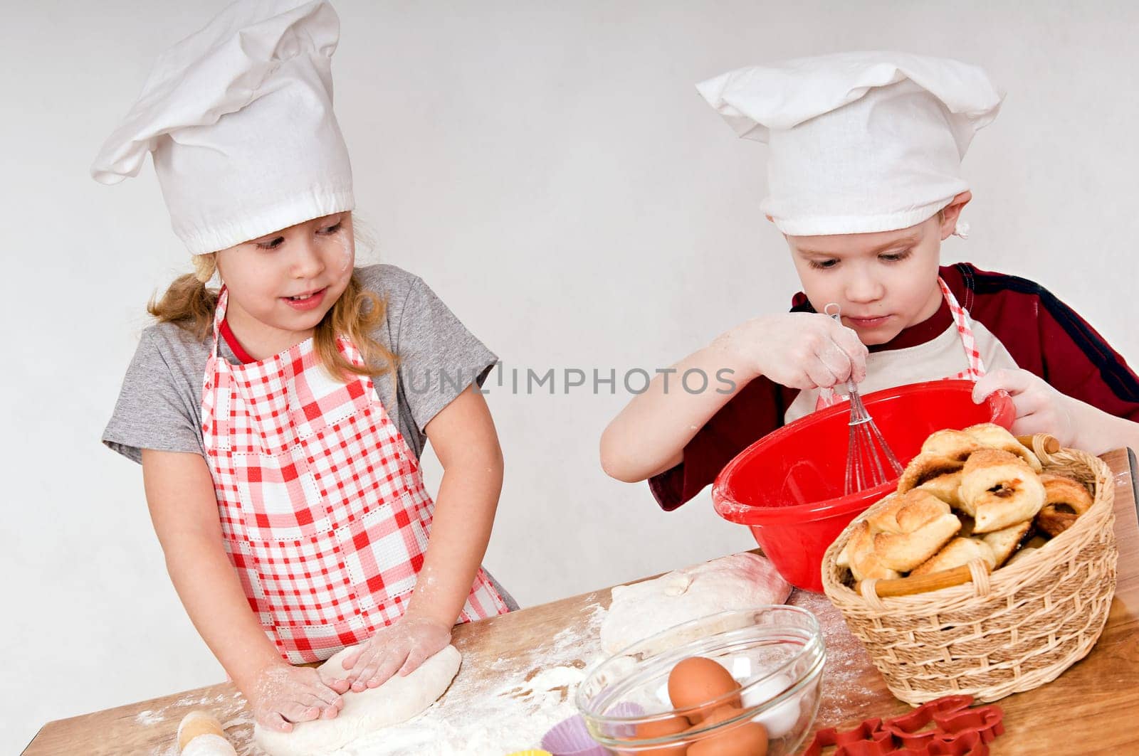 two children in chef&#039 s hats on grey background