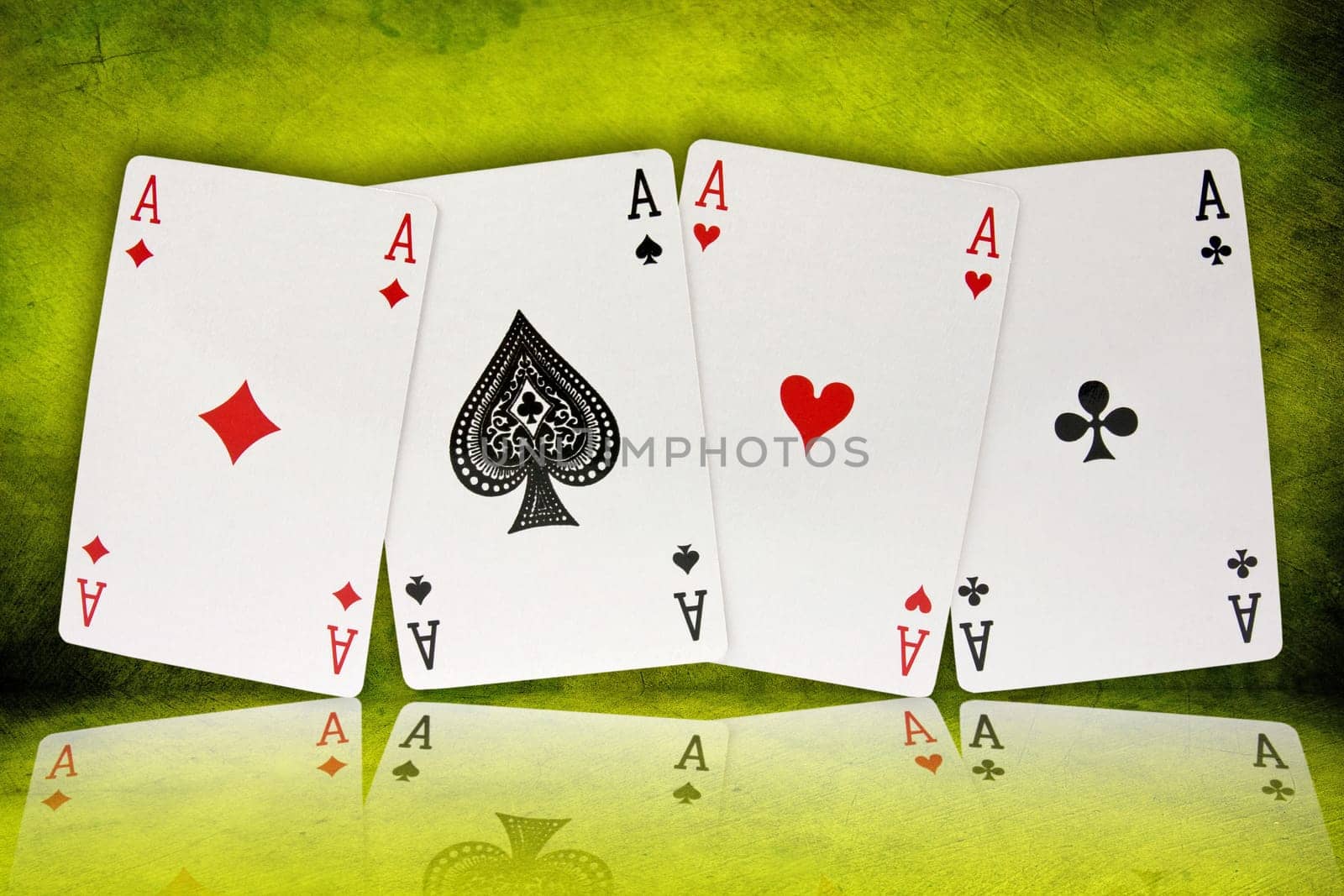 four aces with reflection on green background