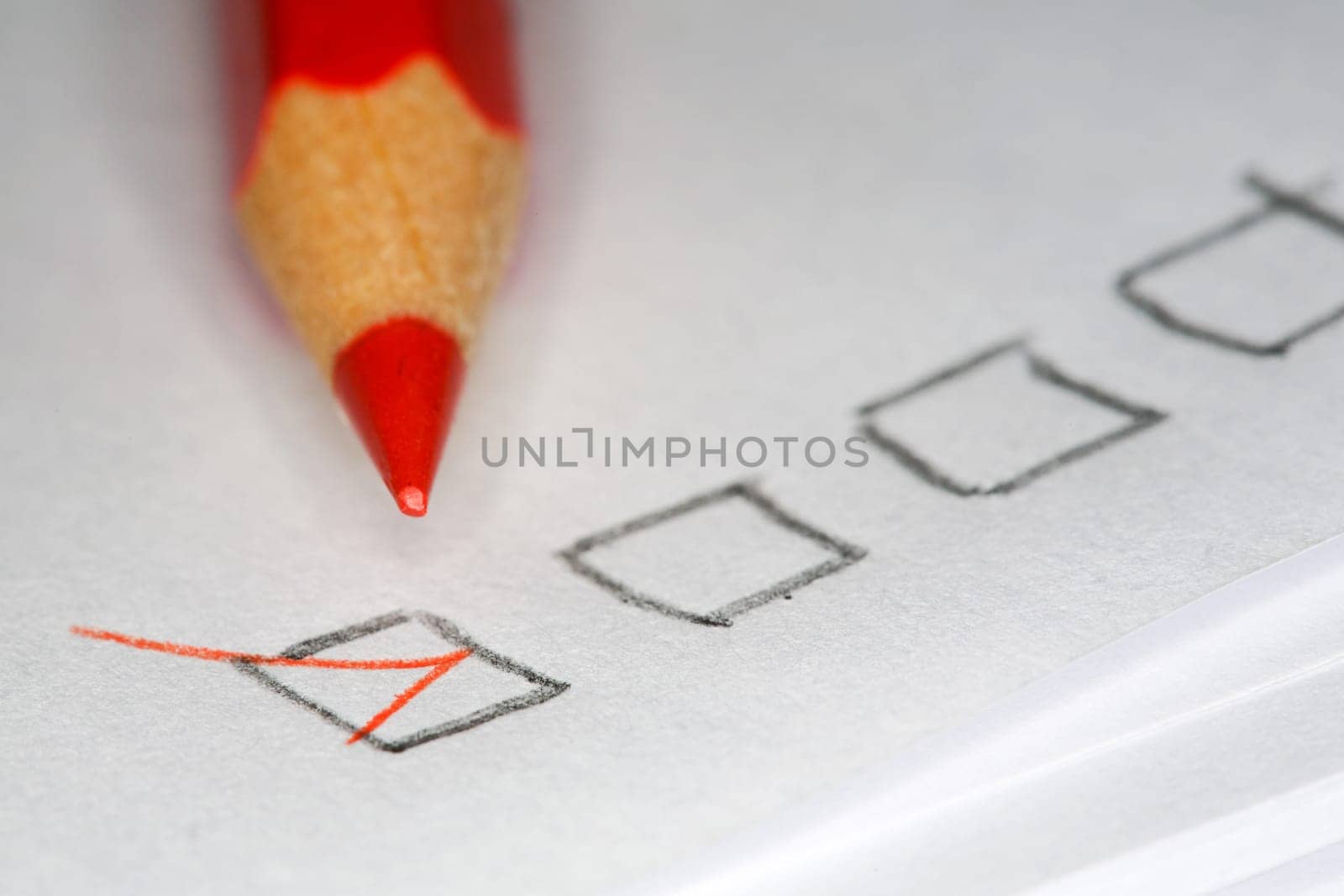 Closeup image of red pencil laying on sheet of paper