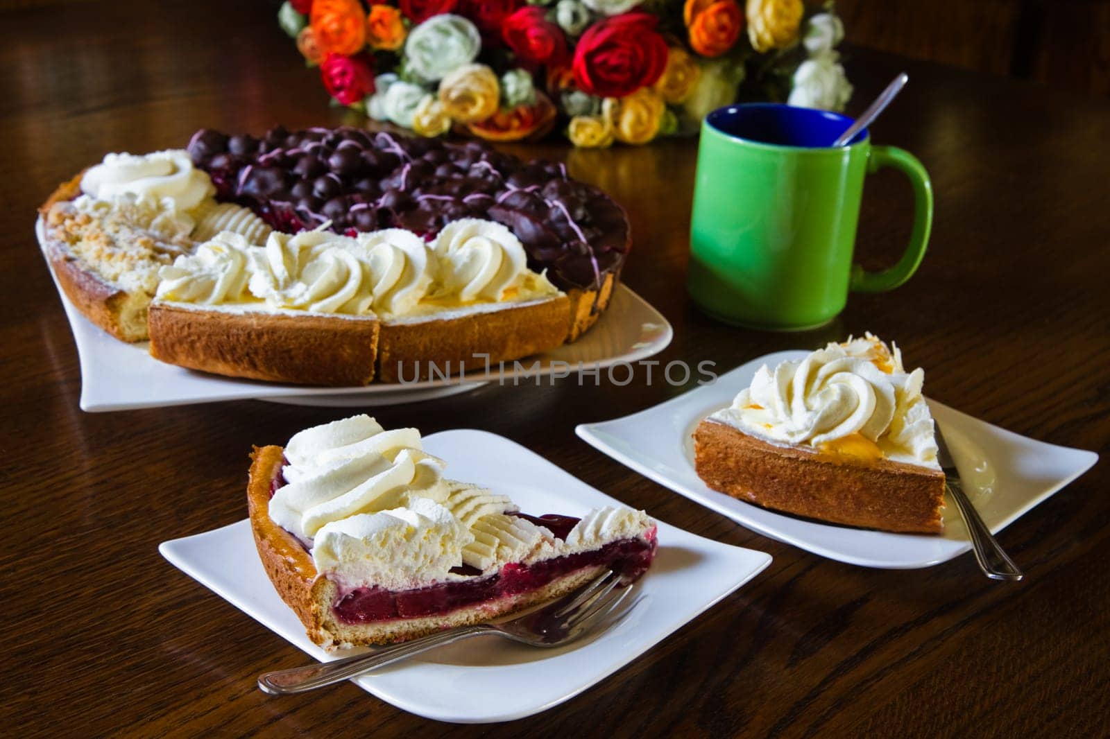Different Dutch pastry or Limburgian flans with cups, mugs and flowers prepared for a party - horizontal
