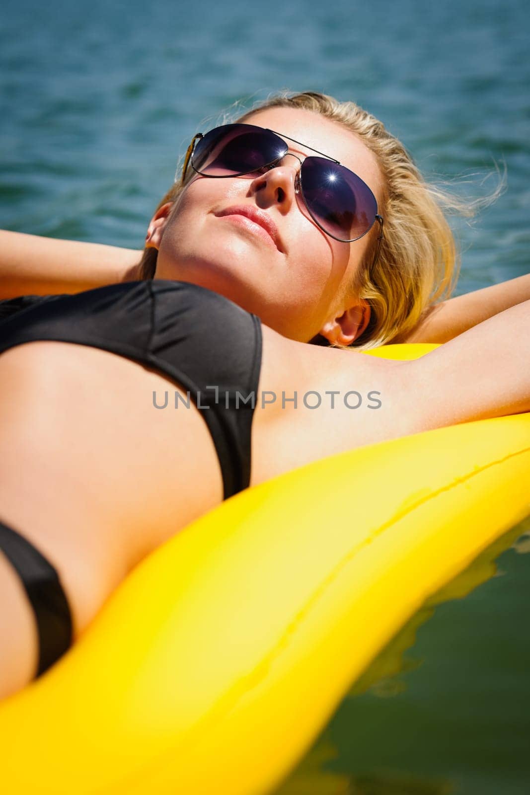 Summer woman sunbathing relax on water floating mattress sunny day
