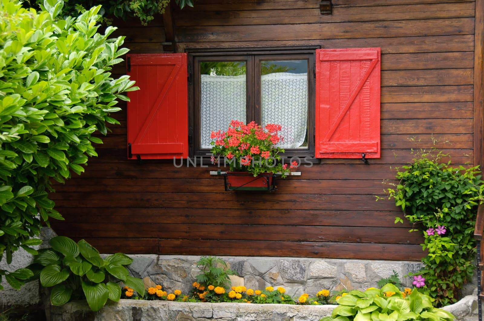 small wooden house with red windows