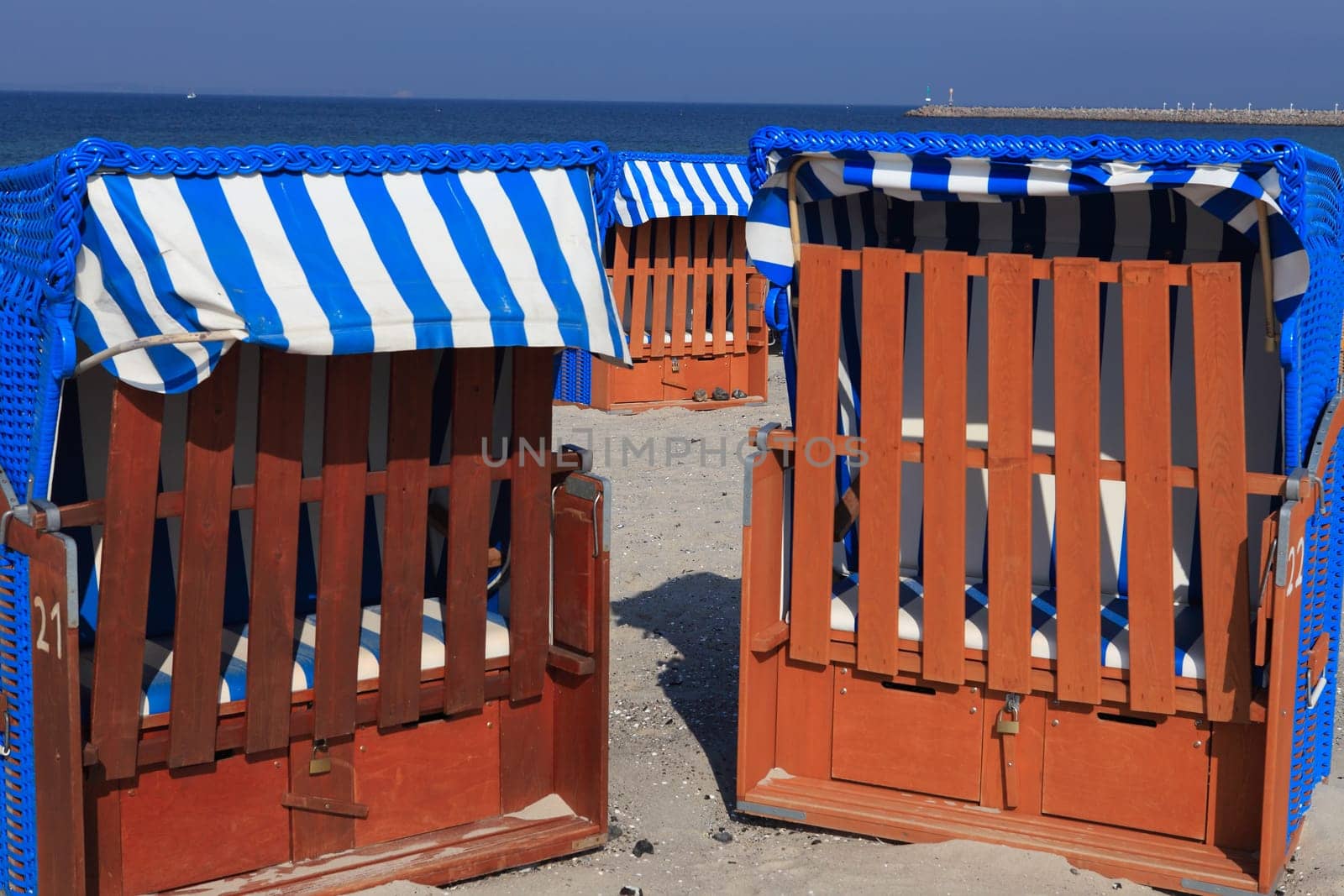 Two blue and white striped beach chairs on the Baltic Sea