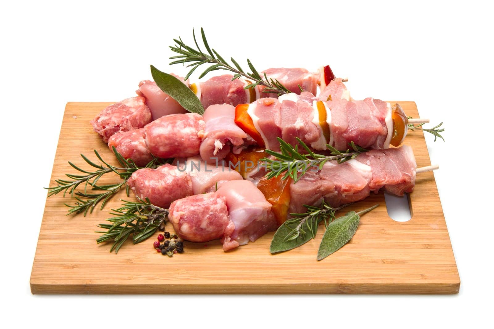 Meat and pepper skewers on a wooden cutting board