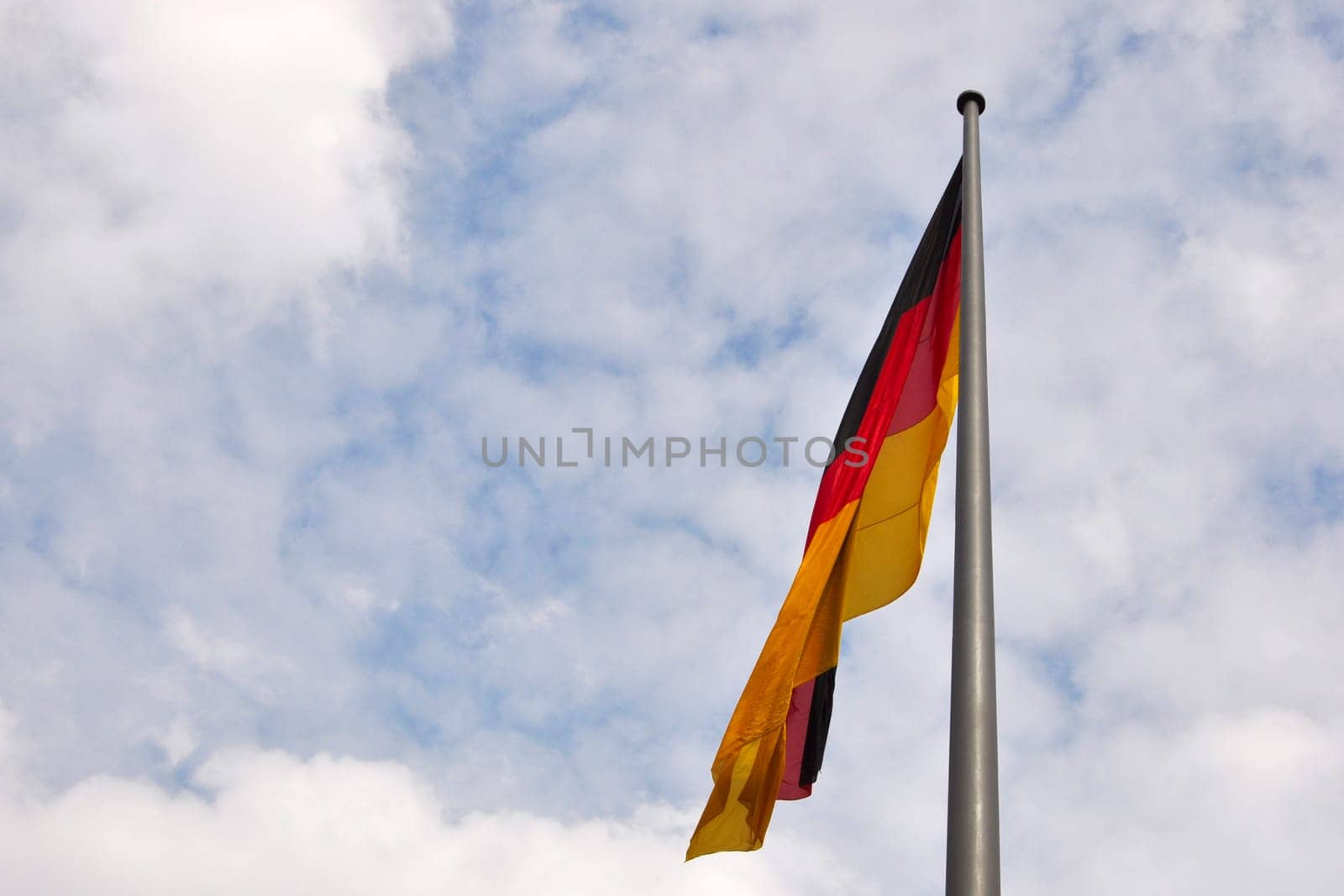 German flag on a pole against sloudy sky