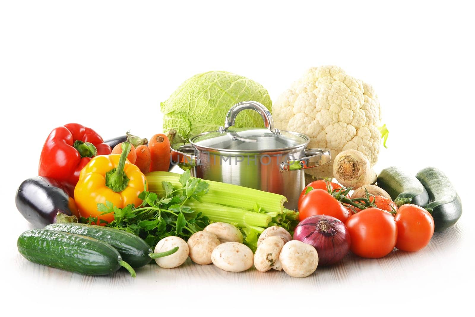 Composition with pot and fresh vegetables isolated on white