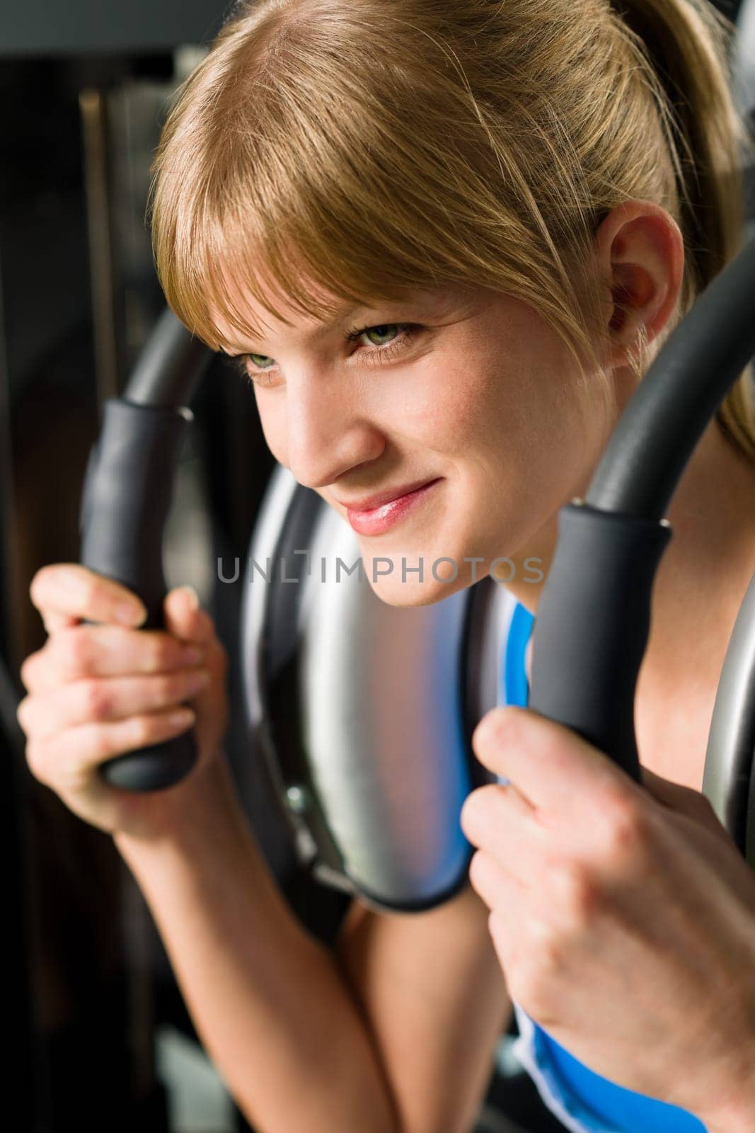 Young woman at gym exercise abdominal muscles on machine