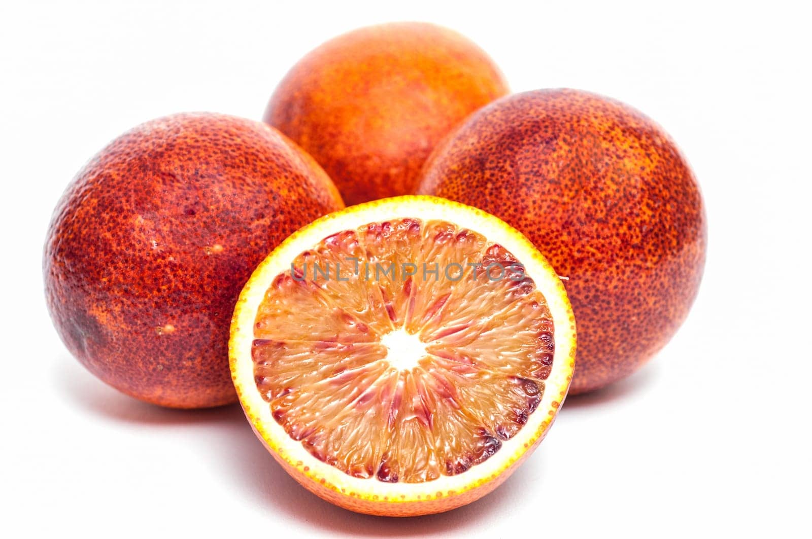 Four Moro blood oranges,one of which is sliced open