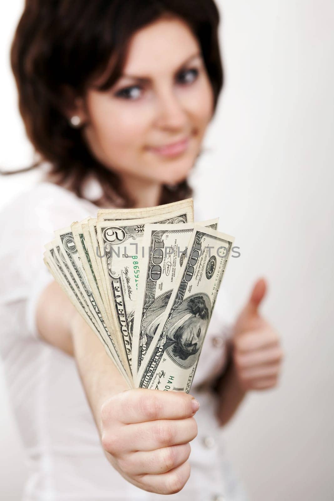 A girl in a white blouse with dollars in her hand