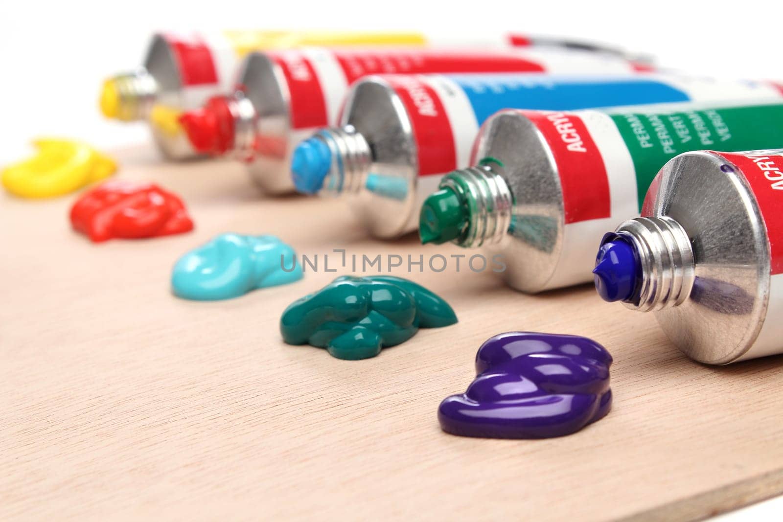 Five paint tubes over a pallete