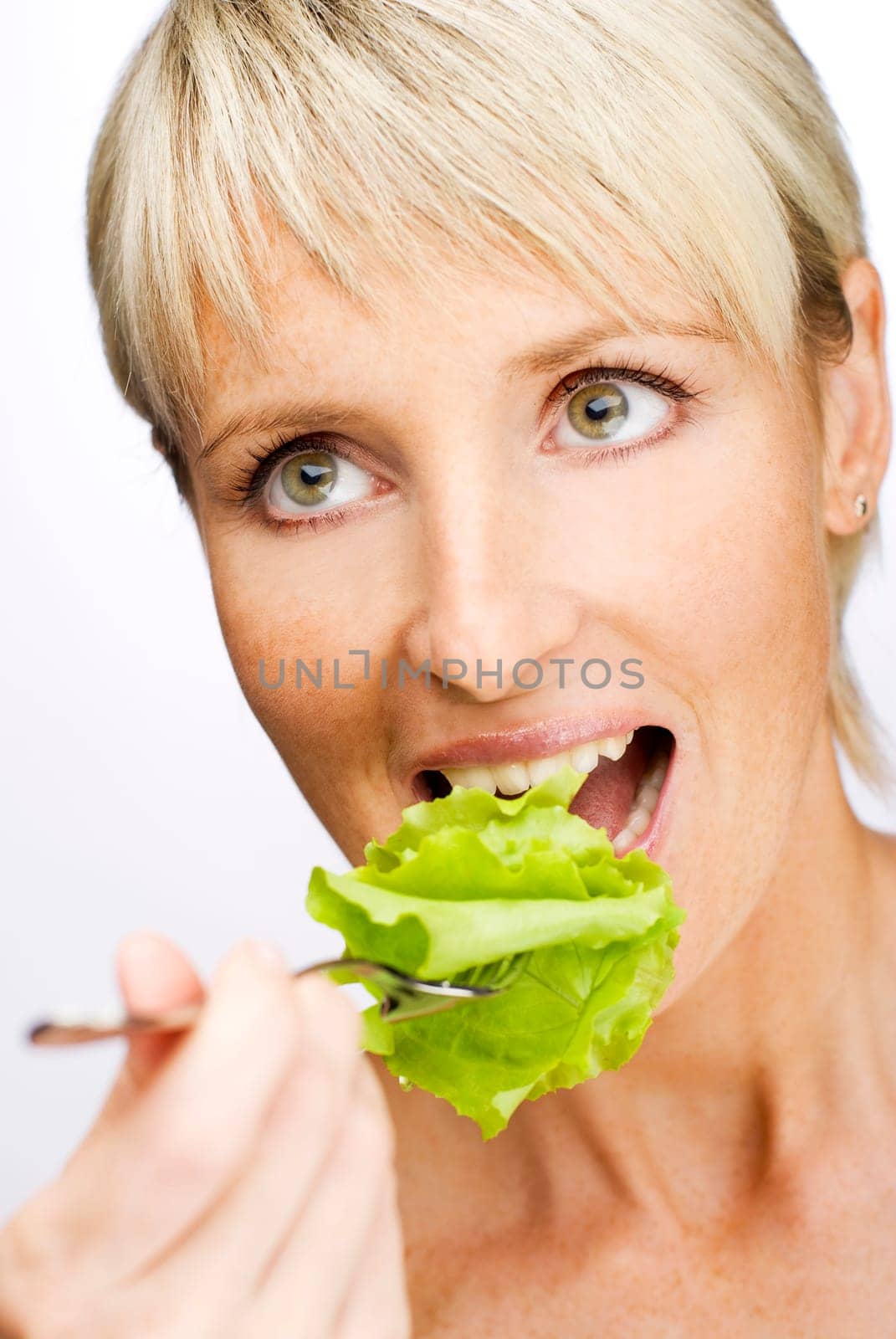 young beautiful blond woman eating salad close up