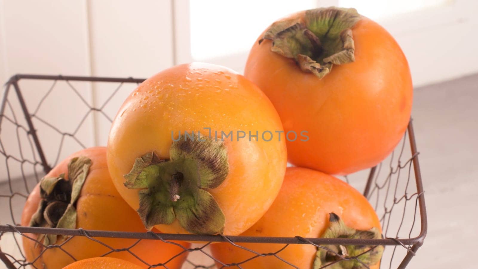 Delicious fresh persimmon fruit on kitchen countertop.