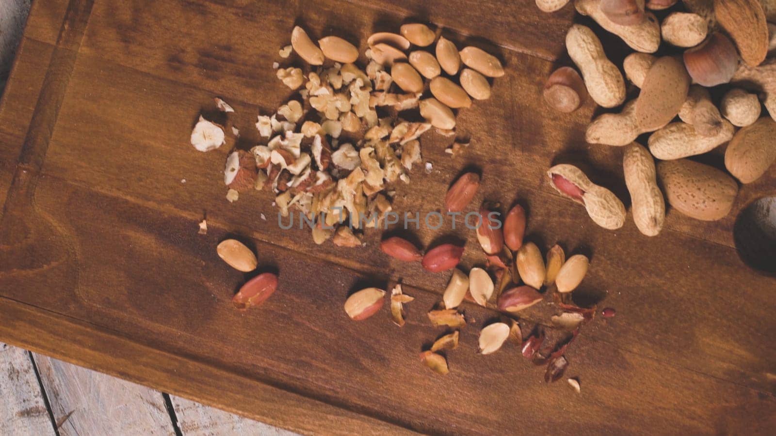 Walnuts, hazelnuts, peanuts and nuts on wooden table.