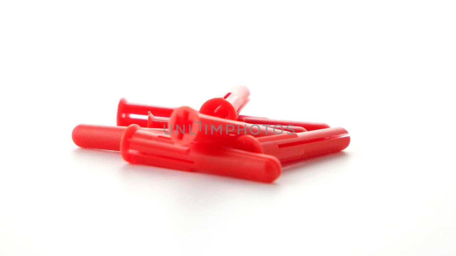 Red plastic dowels isolated on white background.