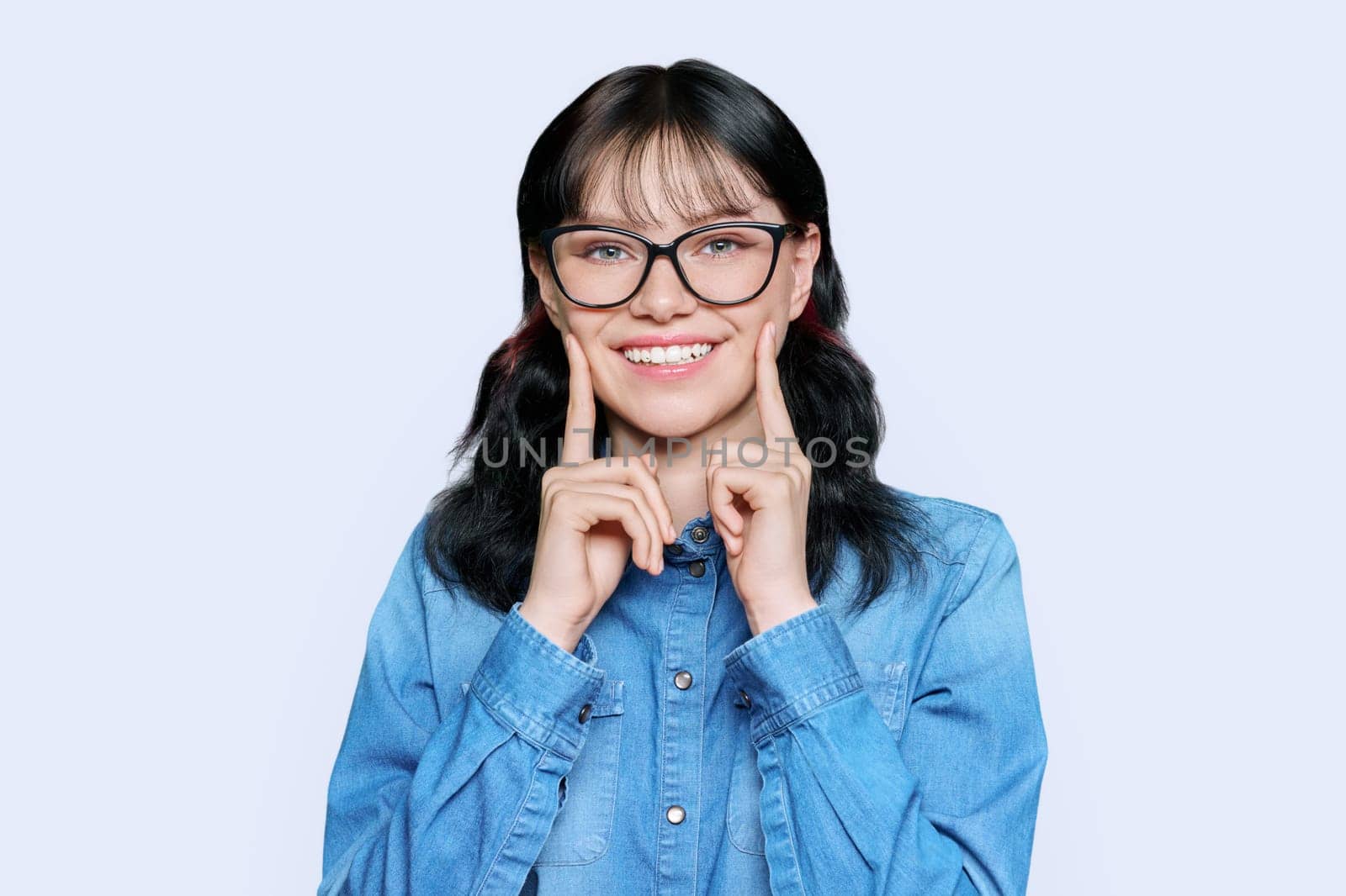 Young woman showing smile with teeth, on white background by VH-studio