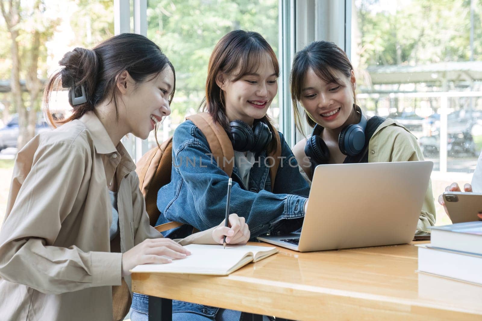 A group of Asian college students join together to share ideas, do homework or study with passion..