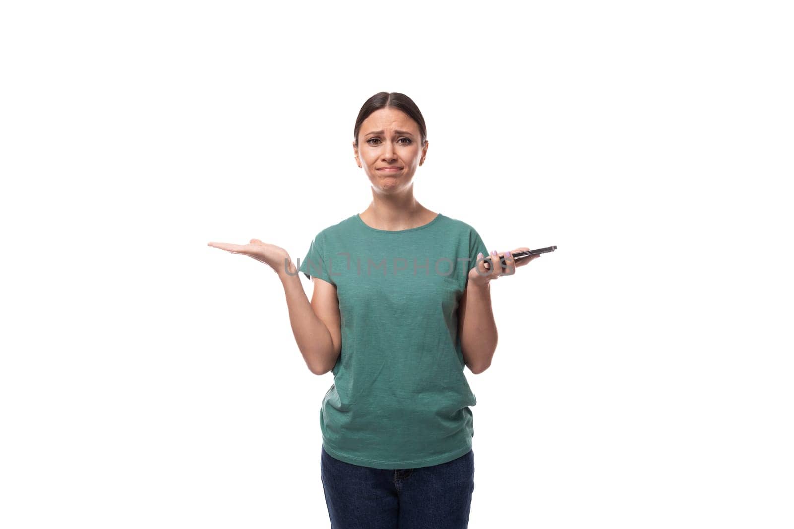young slender woman dressed in a green basic t-shirt with a mockup looks confused by TRMK