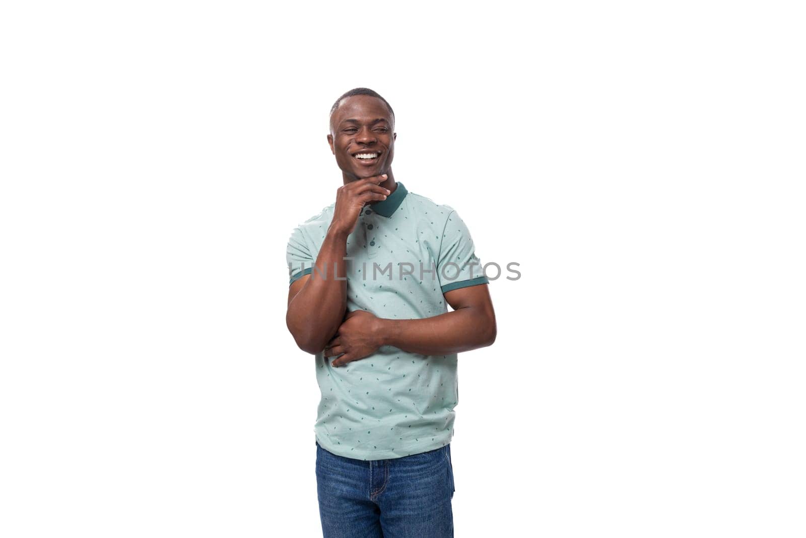 young slender american man dressed in a t-shirt smiles cutely on a white background.