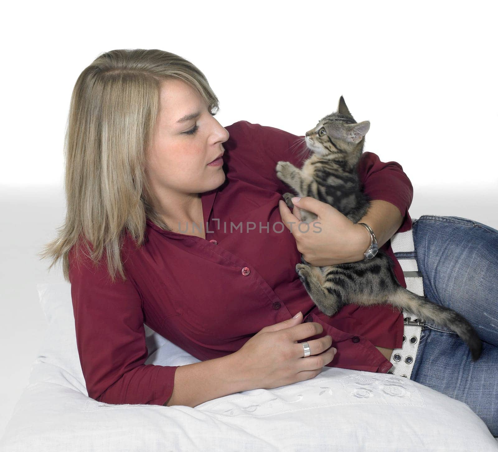 cute girl holding a small kitten in light back